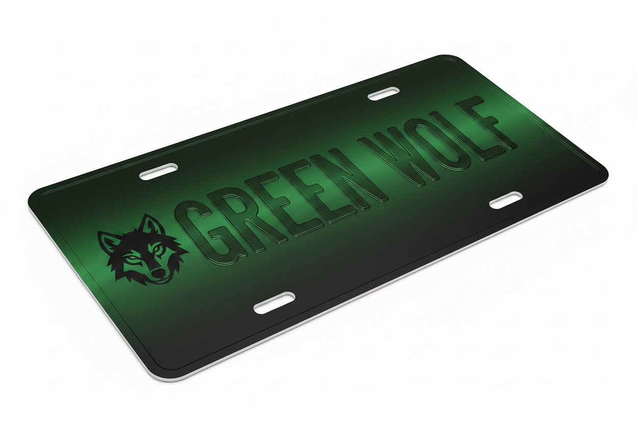A rectangular license plate with rounded corners, featuring a green-to-black gradient design, the text 'GREEN WOLF' in raised lettering, and a wolf head logo on the left. The plate is shown at an angle on a plain white background.